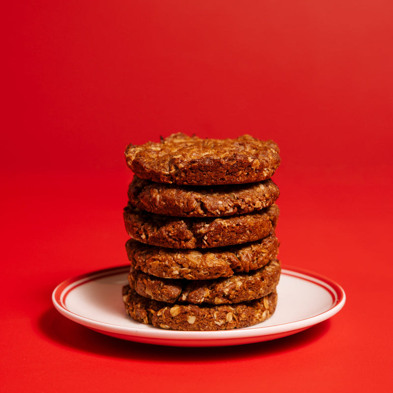 Stack of cookies on a white plate with a red background